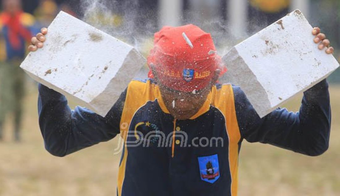 Seorang Prajurit Batalyon Infanteri Para Raider 501/Bajra Yudha mematahkan beton dengan menggunakan kepala dalam atraksi sertijab Komandan Batalyon Infanteri Para Raider 501/Bajra Yudha, Minggu (23/10). Foto : WS Hendro/Radar Madiun/JPNN - JPNN.com