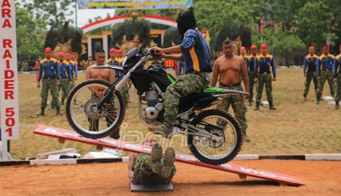 Seorang Prajurit Batalyon Infanteri Para Raider 501/Bajra Yudha melindas rekanya yang terlentang diatas papan berpaku dengan motor trail dalam atraksi sertijab Komandan Batalyon Infanteri Para Raider 501/Bajra Yudha, Minggu (23/10). Foto : WS Hendro/Radar Madiun/JPNN - JPNN.com