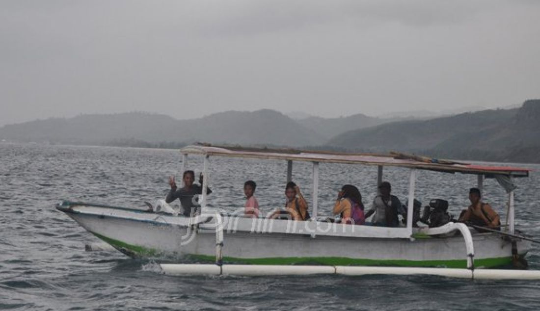 SEMANGAT BELAJAR : Anak-anak warga Dusun Labuan Cenik menggunakan perahu menuju sekolah. Sabtu (22/10). Perahu menjadi alat transportasi satu-satunya ke sekolah ini. Foto : Zainuddin/Lombok Post/JPNN - JPNN.com