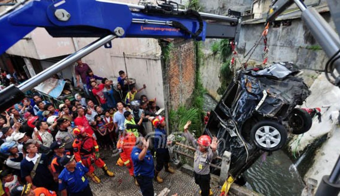 EVAKUASI: Petugas dengan alat berat berusaha megevakuasi sebuah mobil yang sempat hanyut terbawa arus di Sungai Citepus, Pasir Koja, Bandung, Selasa (25/10). Mobil tersbeut terbawa derasnya banjir saat terparkir di Jalan Pagarsih, Bandung. Foto: Riana/Radar Bandung - JPNN.com
