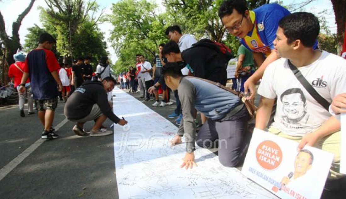 Warga membubuhkan tandatangan pada kain dalam aksi simpatik #savedahlaniskan di Car Free Day (CFD) Simpang Balapan, Malang, Jawa Timur, Minggu (30/10). Foto: Falahi Mubarok/ Radar Malang/JPNN - JPNN.com