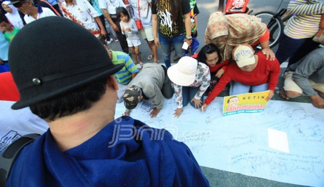 Dengan media kain putih sepanjang kurang lebih 10m di gelar di taman Bungkul , pengunjung di ijinkan membubuhkan tanda tangan beserta kesan pesan untuk Dahlan Iskan, minggu (30/10). Foto : Arya Dhitya/Jawa Pos/JPNN - JPNN.com