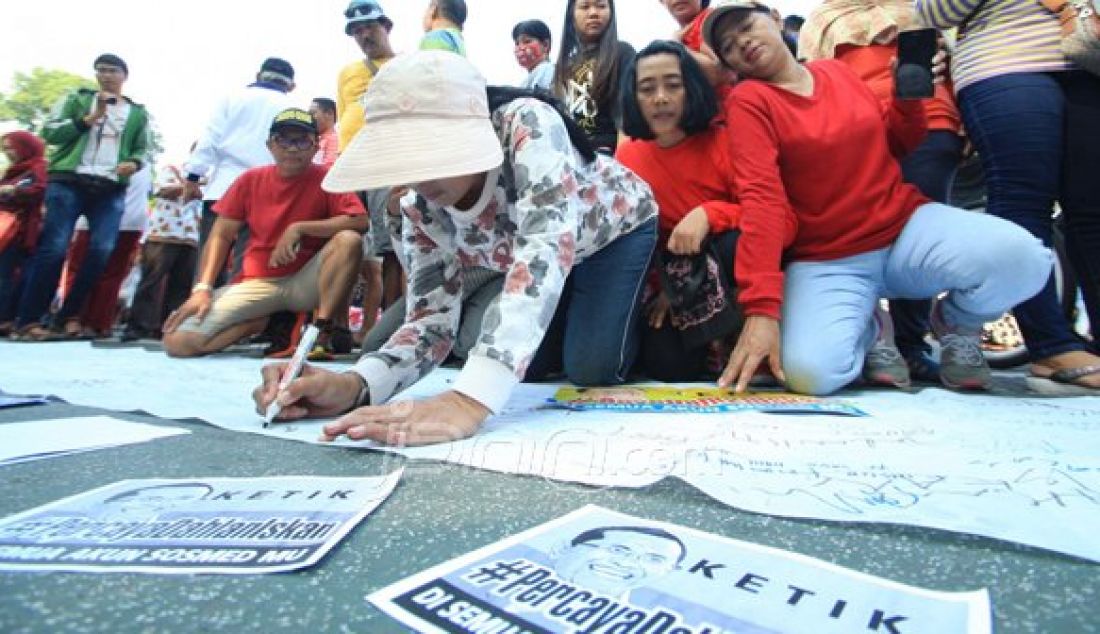 Dengan media kain putih sepanjang kurang lebih 10m di gelar di taman Bungkul , pengunjung di ijinkan membubuhkan tanda tangan beserta kesan pesan untuk Dahlan Iskan, minggu (30/10). Foto : Arya Dhitya/Jawa Pos/JPNN - JPNN.com