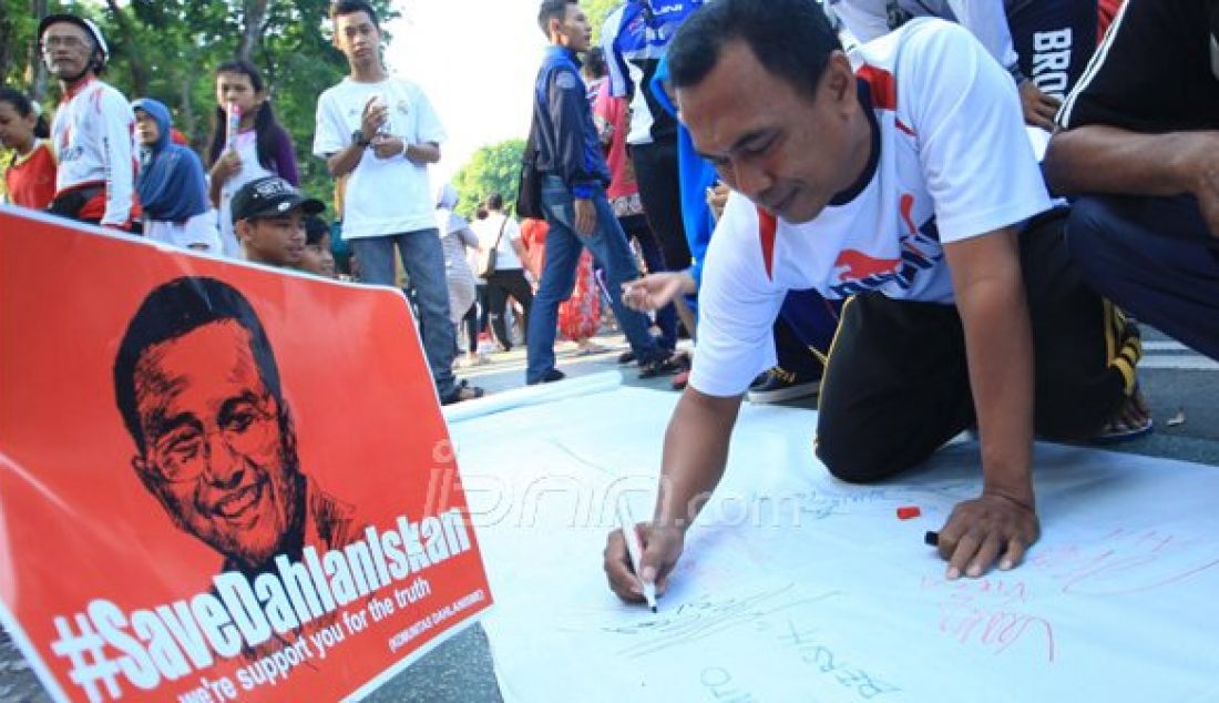 Dengan media kain putih sepanjang kurang lebih 10m di gelar di taman Bungkul , pengunjung di ijinkan membubuhkan tanda tangan beserta kesan pesan untuk Dahlan Iskan, minggu (30/10). Foto : Arya Dhitya/Jawa Pos/JPNN - JPNN.com