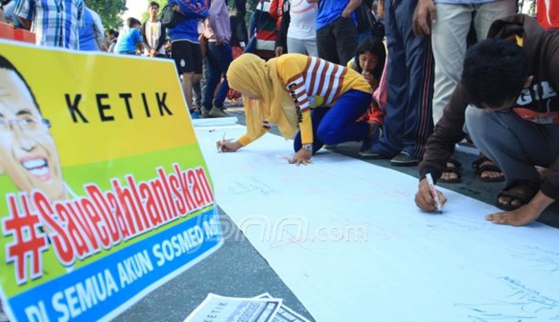 Dengan media kain putih sepanjang kurang lebih 10m di gelar di taman Bungkul , pengunjung di ijinkan membubuhkan tanda tangan beserta kesan pesan untuk Dahlan Iskan, minggu (30/10). Foto : Arya Dhitya/Jawa Pos/JPNN - JPNN.com