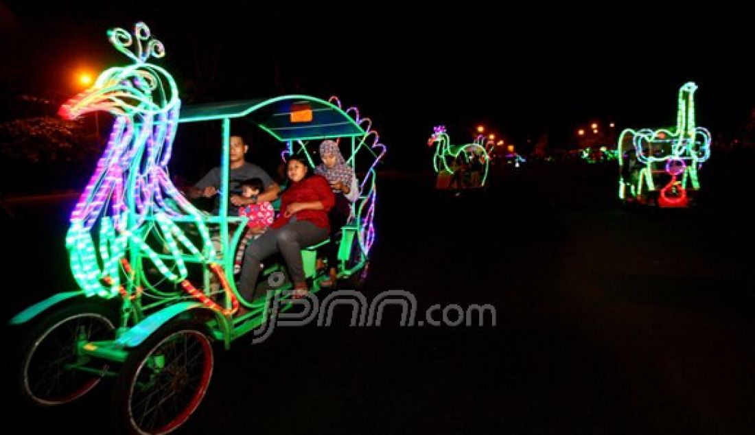 Sejumlah wisatawan menumpang sepeda warna-warni di halaman stadion Kanjuruhan, Kabupaten Malang, Jawa Timur, Minggu Malam (06/11). Wisata tersebut menjadi alternatif wisata murah bagi masyarakat sekitar. Foto: Falahi Mubarok/ Radar Malang/JPNN.com - JPNN.com
