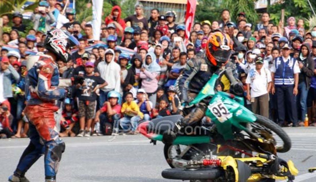 Seorang pembalap menabrak pembalap yang terjatuh pada Road Race Open Tournament MAC-KONI Banggai 2016, bertempat di Sirkuit Tugu Adipura Luwuk, Minggu (6/11). Foto: M Taufik/Luwuk Post - JPNN.com