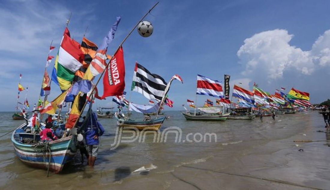 Kirab perahu untuk merayakan sedekah laut dengan hiasan bendera warna-warni di Desa Kradenan Kecamatan Palang Kabupaten Tuban, Minggu (13/11). Foto : Canggih Putranto/Radar Tuban/JPNN.com - JPNN.com