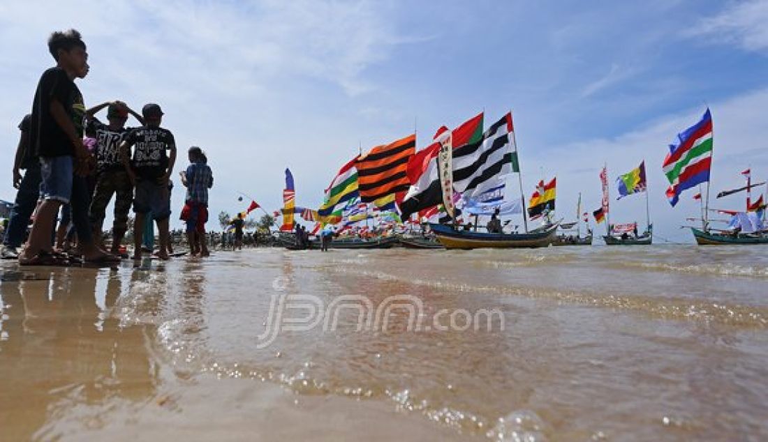 Kirab perahu untuk merayakan sedekah laut dengan hiasan bendera warna-warni di Desa Kradenan Kecamatan Palang Kabupaten Tuban, Minggu (13/11). Foto : Canggih Putranto/Radar Tuban/JPNN.com - JPNN.com