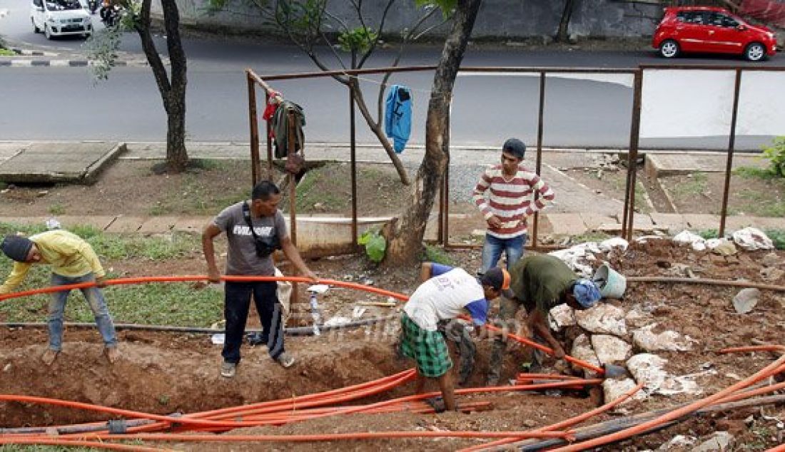 Pekerja saat memasang kabel instalasi fiber optik bawah tanah (fiber optic) di Kawasan Kebon Jeruk, Jakarta Barat, Kamis (22/12). Sistem telepon, sistem TV kabel serta jaringan Internet yang menggunakan media instalasi fiber optik bawah tanah ini terus di - JPNN.com