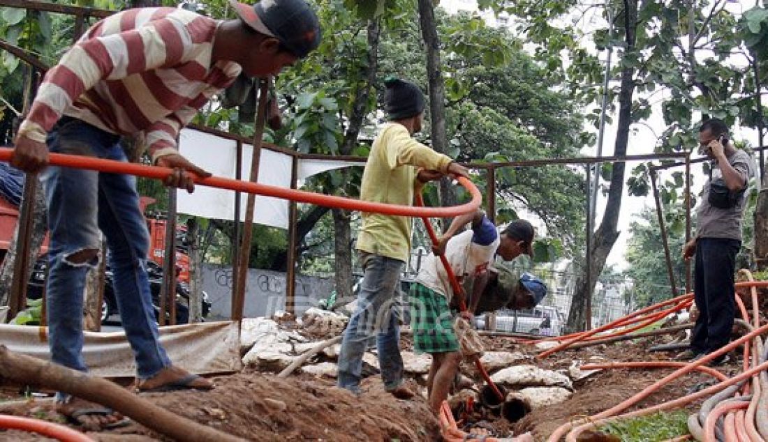 Pekerja saat memasang kabel instalasi fiber optik bawah tanah (fiber optic) di Kawasan Kebon Jeruk, Jakarta Barat, Kamis (22/12). Sistem telepon, sistem TV kabel serta jaringan Internet yang menggunakan media instalasi fiber optik bawah tanah ini terus di - JPNN.com