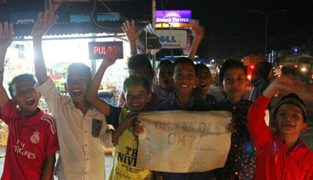 Demam 'Telolet Om' ternyata sudah sampai hingga ke Pekanbaru. Nampak sejumlah anak dengan membawa poster meneriaki setiap bus yang melintas. Foto: Arief B/Riau Pos - JPNN.com