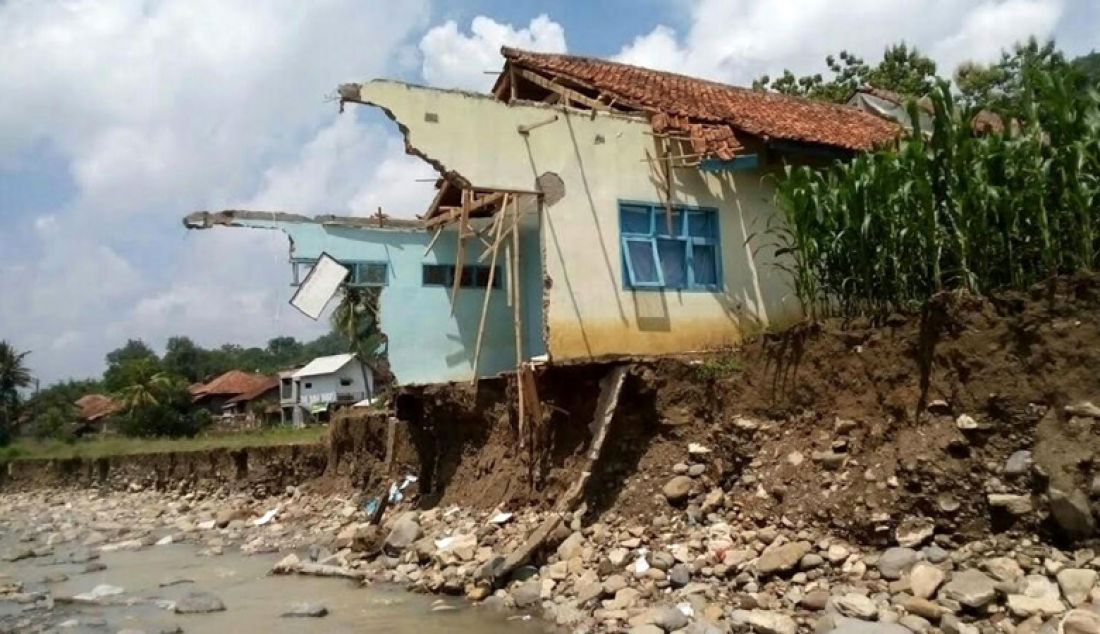 DITERJANG BANJIR: Ruangan Kelas VII SMP Islam Nunuk, Kabupaten Majalengka hancur diterjang banjir, Minggu (1/1). Sapuan banjir tinggal menyisakan tembok sekolah yang menggantung di atas sungai. Foto: Agus R/Radar Majalengka - JPNN.com