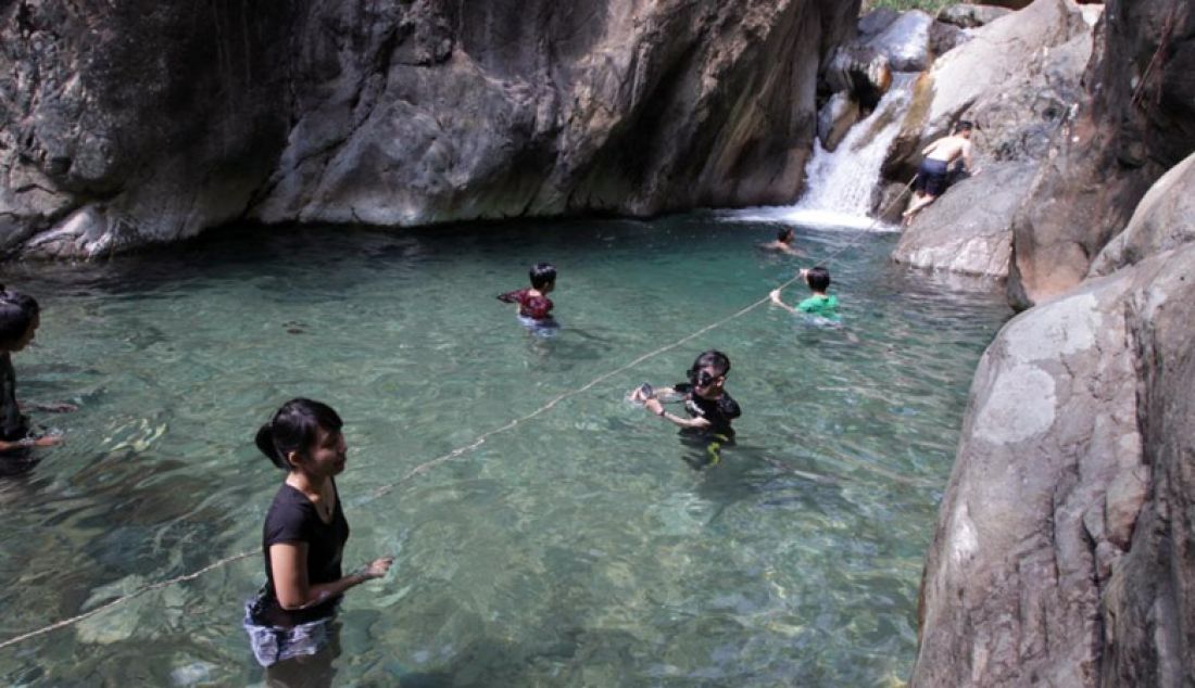 Sejumlah warga nampak asik bermain air di air terjun Curug Hejo, yang ada di kecamatan Babakanmadang, kabupaten Bogor, Senin (2/1). Foto: Sofyan/Radar Bogor - JPNN.com