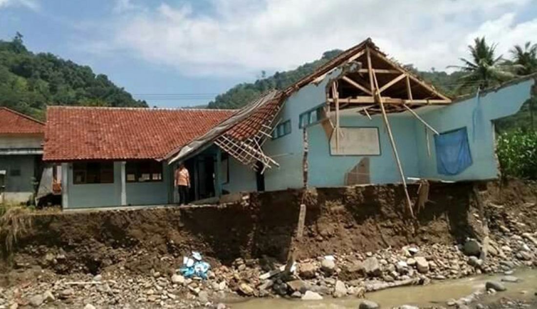 DITERJANG BANJIR: Ruangan Kelas VII SMP Islam Nunuk, Kabupaten Majalengka hancur diterjang banjir, Minggu (1/1). Sapuan banjir tinggal menyisakan tembok sekolah yang menggantung di atas sungai. Foto: Agus R/Radar Majalengka - JPNN.com