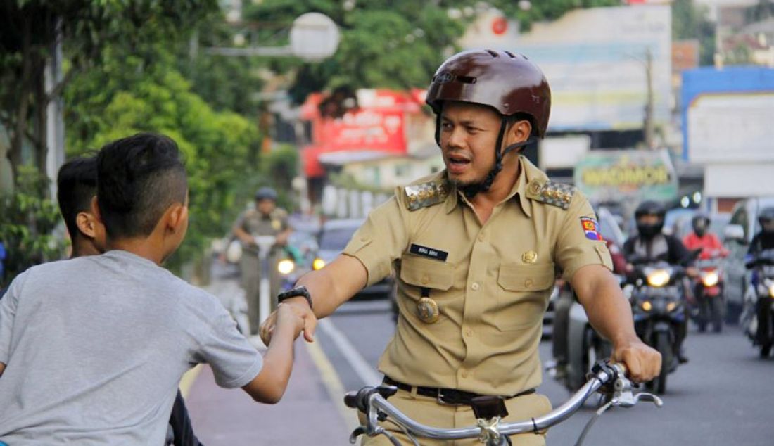 Wali kota Bogor Bima Arya menyapa sejumlah anak penghadang pengendara motor yang mencoba menggunakan lajur khusus sepeda di Jalan Otista, Kota Bogor, Rabu (4/1). - JPNN.com