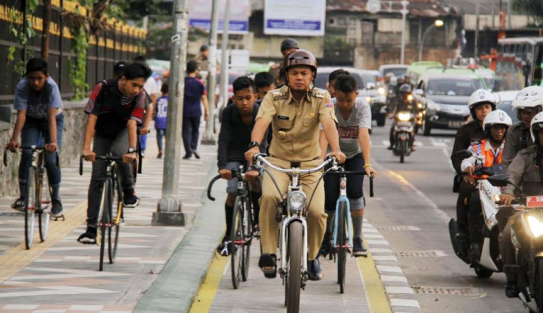 Wali kota Bogor Bima Arya bersepeda menyusuri jalan Otista bersama sejumlah anak-anak Bogor, Rabu (4/1). - JPNN.com