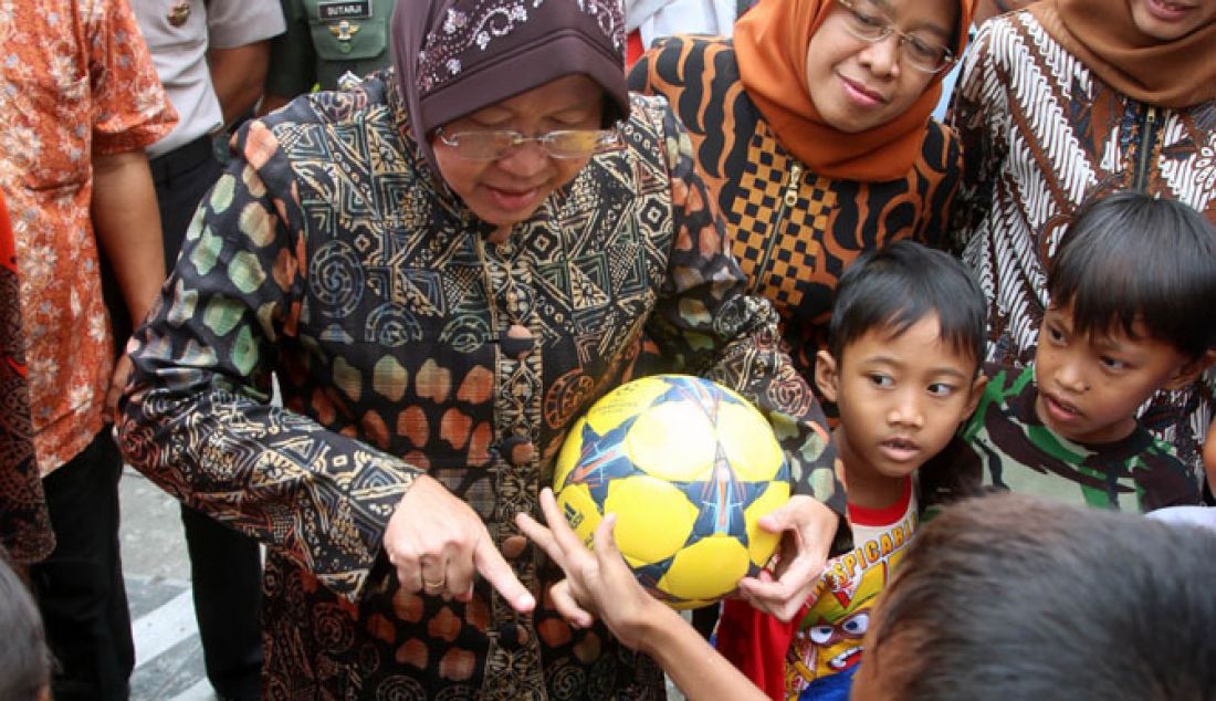 AYO SUT: Usai meresmikan box culvert di Sidotopo Wetan, Wali Kota Tri Rismaharini sambil membawa bola bercengkrama dengan bocah setempat, Jumat (6/1). - JPNN.com