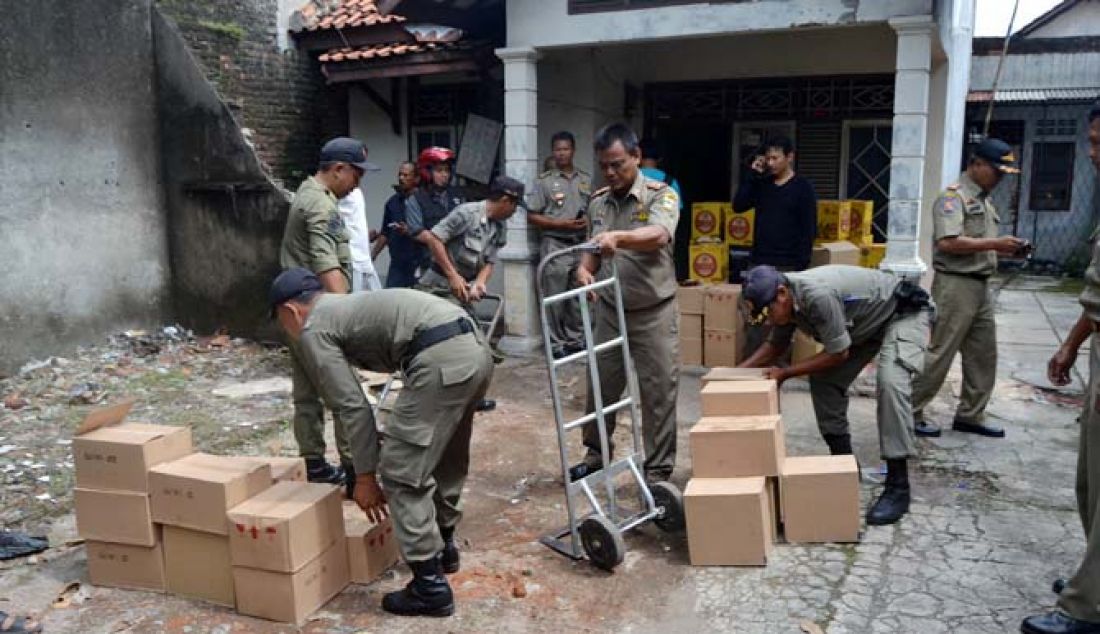 GUDANG MIRAS: Anggota Satpol PP Kota Cirebon berhasil membongkar sebuah gudang di Kp Karang Anom, Pegambiran, Cirebon, yang digunakan sebagai penyimpanan miras untuk distribusi wilayah III Cirebon, Selasa (10/1). - JPNN.com