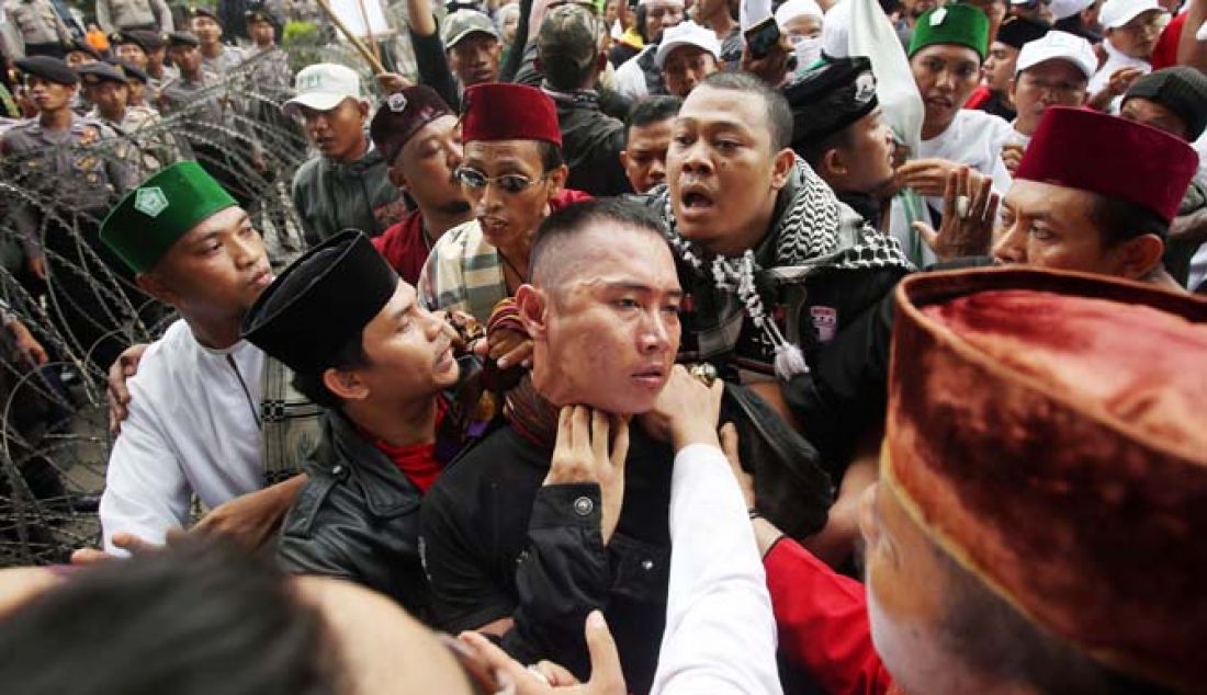 Massa mengamankan seorang pria yang diduga provokator saat aksi unjuk rasa di luar ruang persidangan kasus dugaan penistaan agama dengan terdakwa Gubernur nonaktif DKI Jakarta Basuki Tjahaja Purnama di depan Kementerian Pertanian, Jakarta, Selasa (10/1). Sempat terjadi kericuhan akibat peristiwa tersebut. - JPNN.com