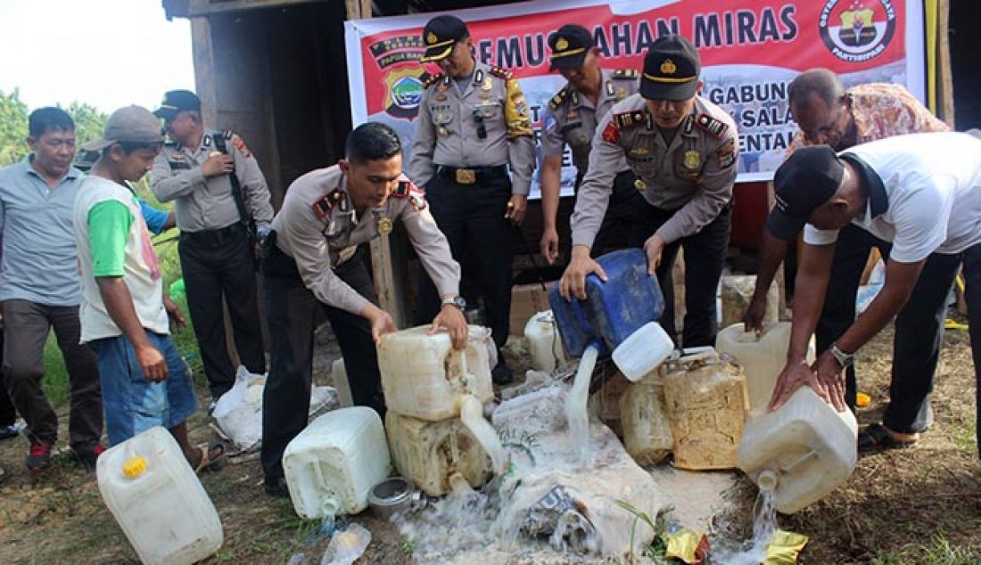 Anggota Polres Sorong bersama dengan anggota Polsek Sorong memusnahkan miras di Distrik Salawati, Rabu (11/1). - JPNN.com