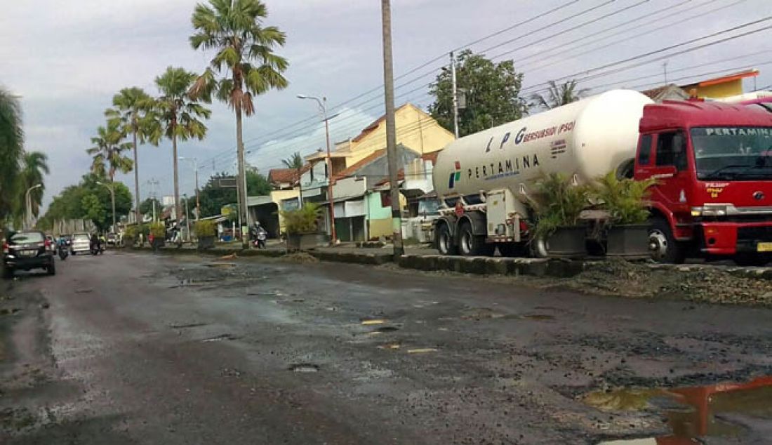 Jalan Urip Sumoharjo di wilayah kota Cilacap terlihat banyak berlubang di sepanjang jalan tersebut, Selasa (17/1). Pemerintah Kabupaten Cilacap menyatakan perbaikan jalan tersebut menunggu lelang yang diperkirakan baru dimulai Maret mendatang. - JPNN.com