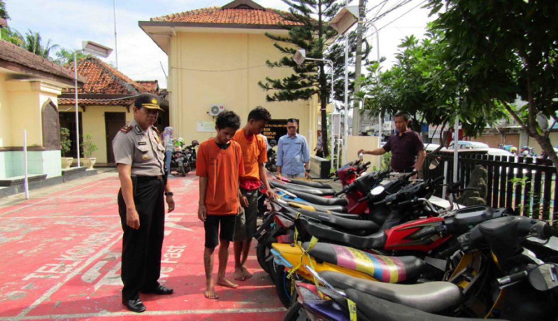 Dua pelaku pencurian kendaraan bermotor (curanmor) berdiri didepan barang bukti usai dibekuk oleh anggota Reserse Kriminal (Reskrim) Polsek Serang. Kedua pelaku itu khusus beroperasi parkir Pasar Induk Rau (PIR), Kota Serang. - JPNN.com