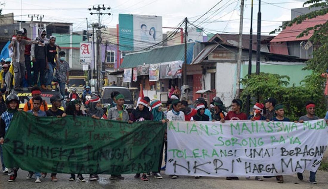 Ratusan massa yang tergabung dalam kelompok organisasi kemasyarakatan, organisasi kepemudaan, mahasiswa, keagamaan, dan beberapa aliansi di Sorong Raya melakukan longmach dari Taman DEO menuju Kantor DPRD Kota Sorong, minta FPI dibubarkan, Kamis (19/1). - JPNN.com