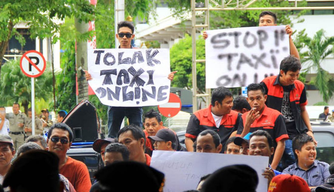 UNJUK RASA: Ratusan pengemudi taksi argo menggelar aksi damai di depan kantor DPRD Balikpapan, Rabu (25/1). Mereka mengeluhkan keberadaan taksi online membuat omzet mereka turun, bahkan harus berutang untuk membayar setoran. - JPNN.com