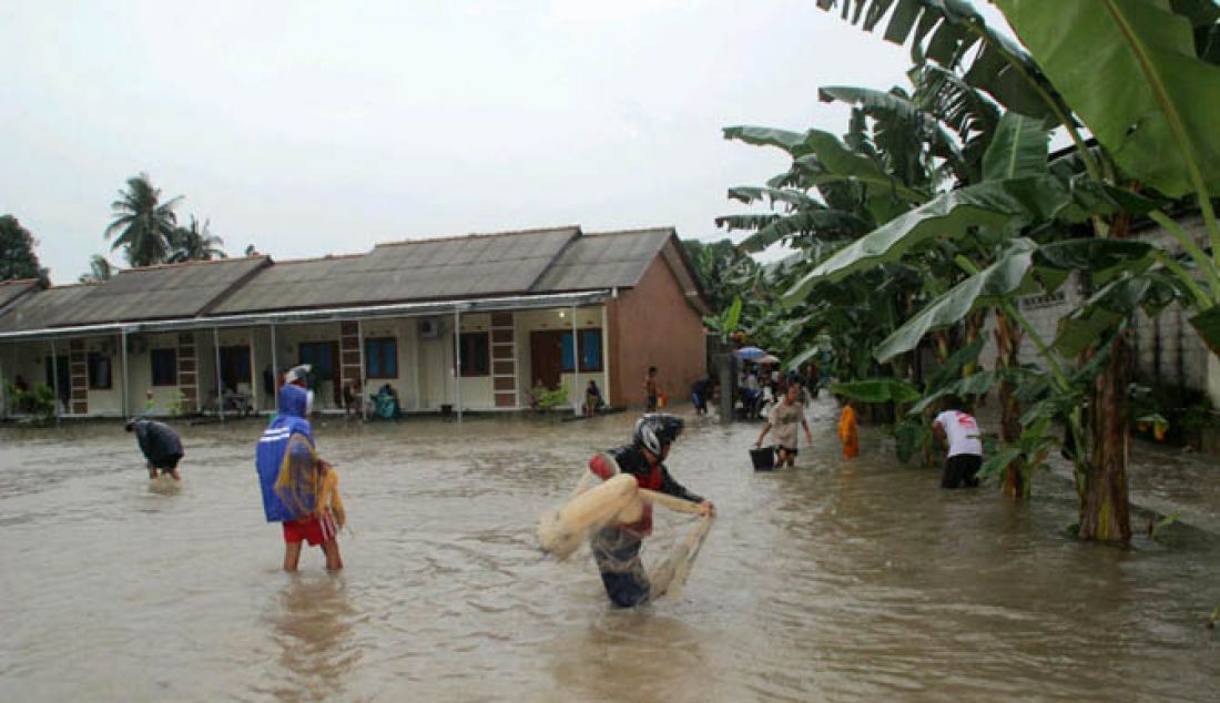 Beberapa Warga tampak memanfaatkan banjir yang menggenangi Lingkungan Sidodadi kelurahan Srimenanti Kecamatan Sungailiat Kabupaten Bangka untuk menangkap ikan, Minggu 29/1). - JPNN.com