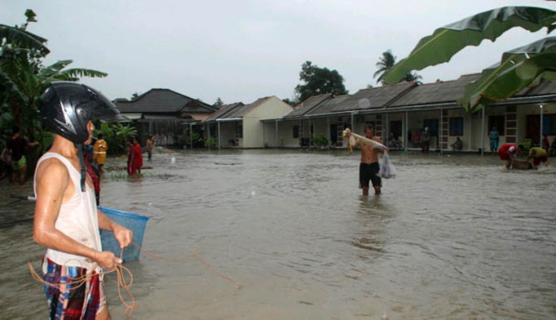 Beberapa Warga tampak memanfaatkan banjir yang menggenangi Lingkungan Sidodadi kelurahan Srimenanti Kecamatan Sungailiat Kabupaten Bangka untuk menangkap ikan, Minggu 29/1). - JPNN.com