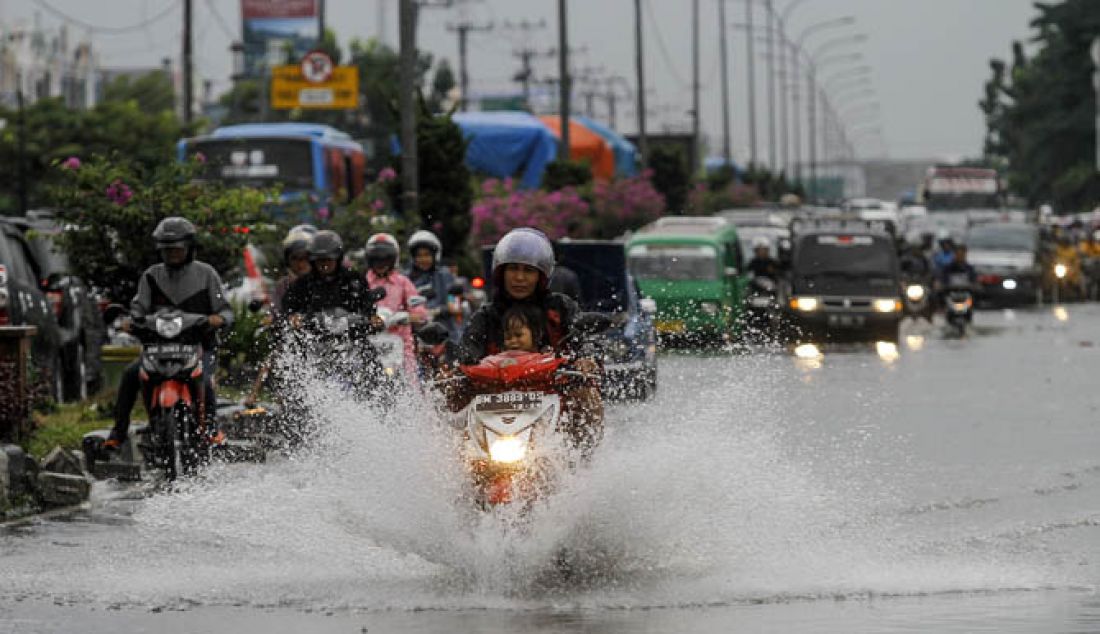 Kendaraan bermotor melewati genangan air di Jalan HR.Soebrantas Pekanbaru. Selasa (31/1/2017). Hujan deras pada selasa pagi membuat Jalan HR.Soebrantas dan beberapa titik Kawasan di Kota Pekanbaru tergenang air. - JPNN.com