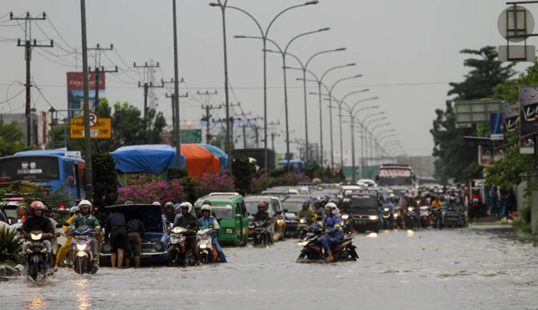 Kemacetan panjang kendaraan bermotor saat mencoba melintasi Jalan HR.Soebrantas Pekanbaru, yang tergenang air. Selasa (31/1/2017). Hujan deras pada selasa pagi membuat Jalan HR.Soebrantas dan beberapa titik Kawasan di Kota Pekanbaru tergenang air. - JPNN.com