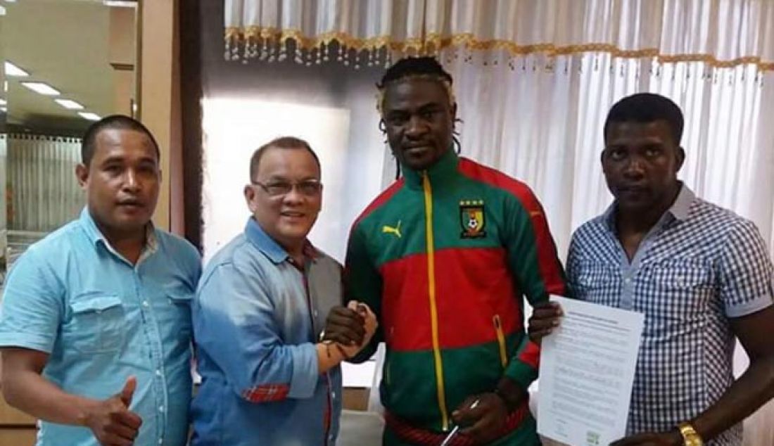 Pesepakbola Bio Paulin, defender naturalisasi asal Kamerun usai tanda tangan pra kontrak bersama Achmad Haris sekretaris Sriwijaya FC di Jakarta, Rabu (1/2) sore. - JPNN.com