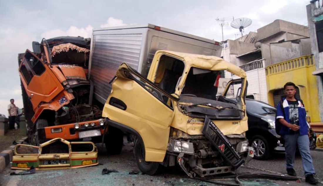 TABRAKAN BERUNTUN: Beberapa warga melihat mobil yang bertabrakan di Fly Over Brayan kota Medan, Senin (6/2). Tabrakan beruntun tersebut di karena kan salah satu mobil mengalami rem blong, dan supir mobil tersebut mengalami luka ringan. - JPNN.com