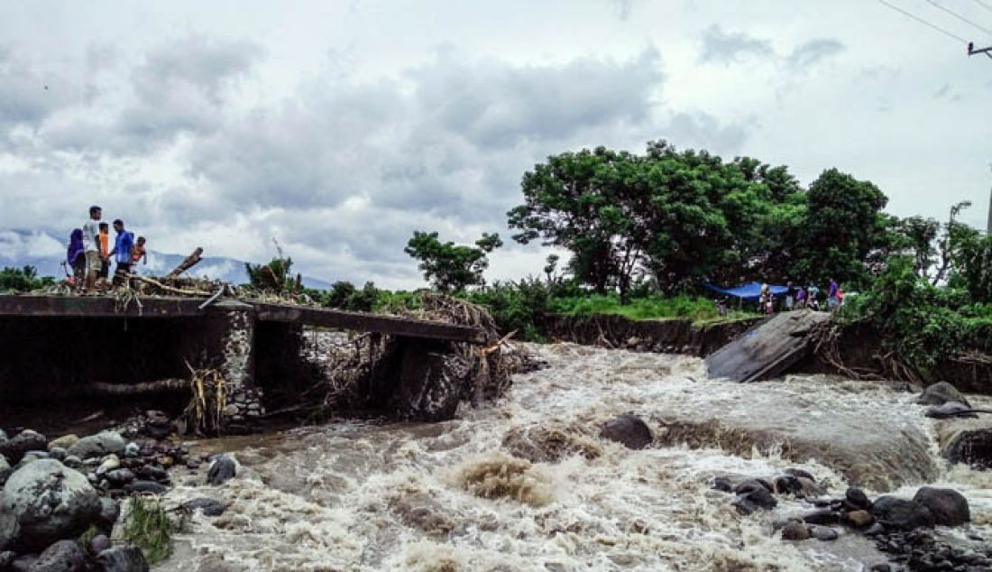 Sejumlah warga melihat kondisi jembatan yang ambruk diterjang banjir di desa Labuan Pandan, Kecamatan Sambelia, Kamis (9/2). - JPNN.com