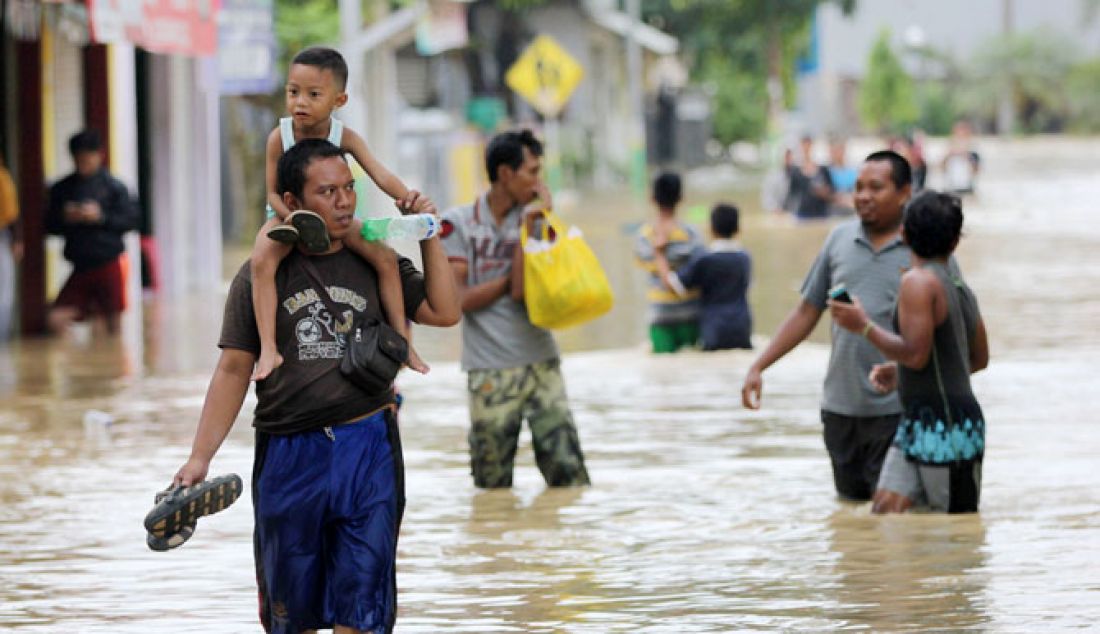 Sebanyak tujuh Desa, enam Kelurahan dan ribuan KK terdampak banjir. Di beberapa titik ketinggian banjir memcapai 210 meter. Terlihat Warga melintasi genangan air banjir yang mengalir cukup deras di Jalan Imam Bonjol, Sampang, Kamis (9/2). - JPNN.com