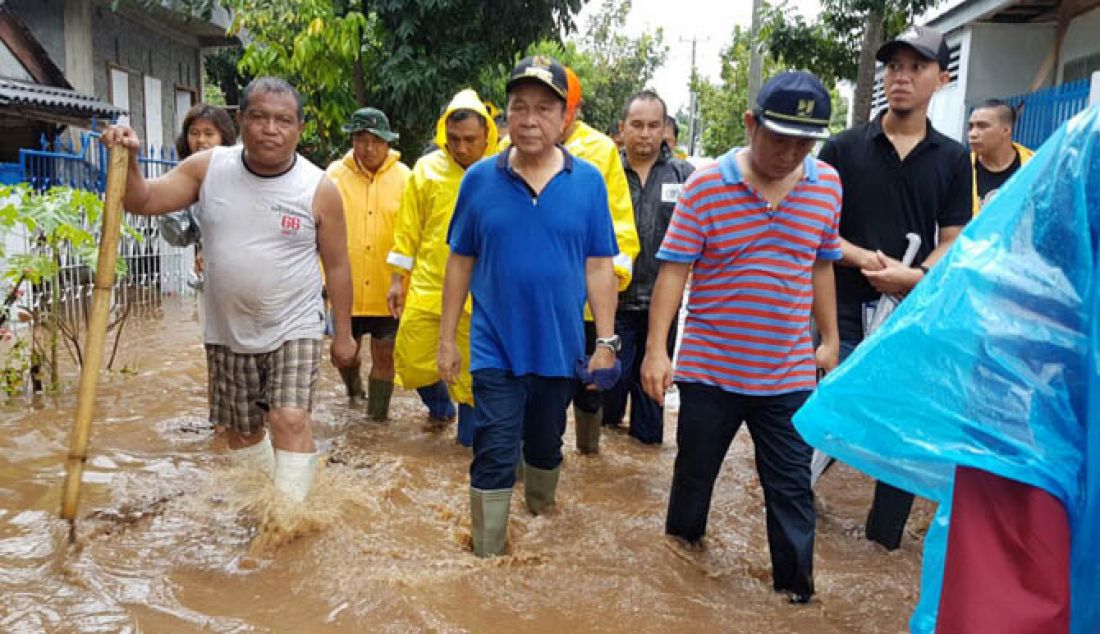 PARAH: Hanya hujan delapan jam, delapan kelurahan di Kota Bitung terendam banjir. Seribu lebih rumah warga terendam banjir setinggi 80 – 120 centimeter. Lima ribu warga diungsikan. Wali Kota Bitung Max Lomban turun ke beberapa lokasi banjir, Minggu (12/2). - JPNN.com