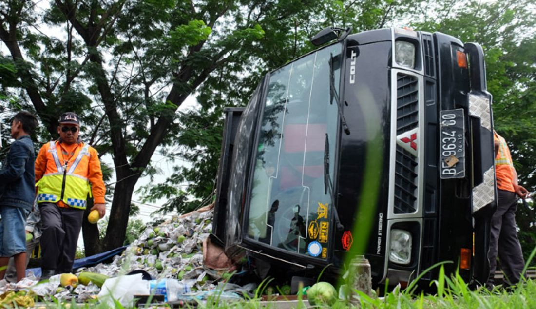 TERBALIK: Sebuah mobil Pickup nopol BE 9634 GO muatan pepaya terguling di KM 90 Tol Tangerang-Merak, Purwakarta, Cilegon, Jumat (17/27). Beruntung tidak ada korban jiwa pada musibah ini. Menurut petugas, mobil pickup muatan pepaya dari Lampung yang akan dibawa ke Tanah Tinggi Tangerang ini mengalami pecah ban. - JPNN.com