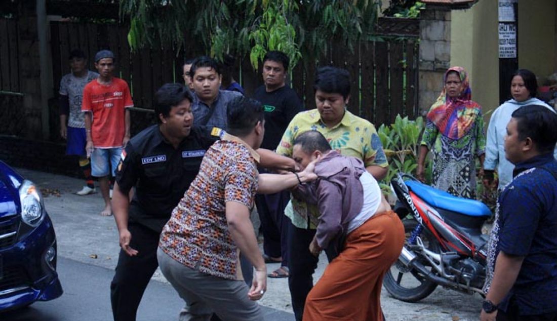 Terduga pengguna narkoba Wawan Iyow ketika didesak penyidik Polda Gorontalo untuk melihat dan mengambil barang bukti narkoba yang dibuangnya di jalan ketika dihadang penyidik, Jumat (17/2) di jalan Joesoef Dali, Kota Tengah, Kota Gorontalo. - JPNN.com