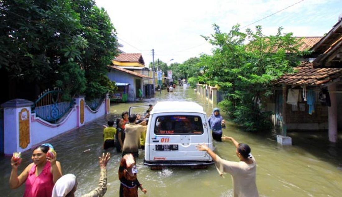 BANTUAN LOGISTIK: Masyarakat Kelurahan Kaligangsa mengerumuni mobil yang membawa dan memberikan bantuan logistik bagi para korban banjir, Jumat (17/2) pagi. - JPNN.com