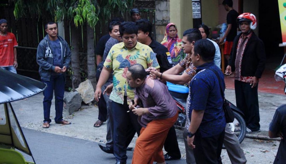 Terduga pengguna narkoba Wawan Iyow ketika didesak penyidik Polda Gorontalo untuk melihat dan mengambil barang bukti narkoba yang dibuangnya di jalan ketika dihadang penyidik, Jumat (17/2) di jalan Joesoef Dali, Kota Tengah, Kota Gorontalo. - JPNN.com