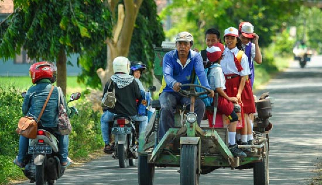 Sejumlah pelajar menumpang gerandong pulang dari sekolah saat melintas jalan desa Sukojati, Kecamatan Kabat, Banyuwangi, Senin (21/2). Gerandong adalah kendaraan roda empat yang dimodifikasi. - JPNN.com