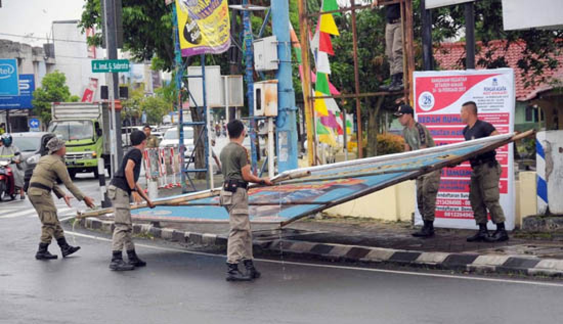 Petugas Satpol PP Kabupaten Banyumas membongkar spanduk yang dipasang bukan pada tempat peruntukannya, Selasa (21-2), di perempatan dr Angka, Purwokerto. - JPNN.com