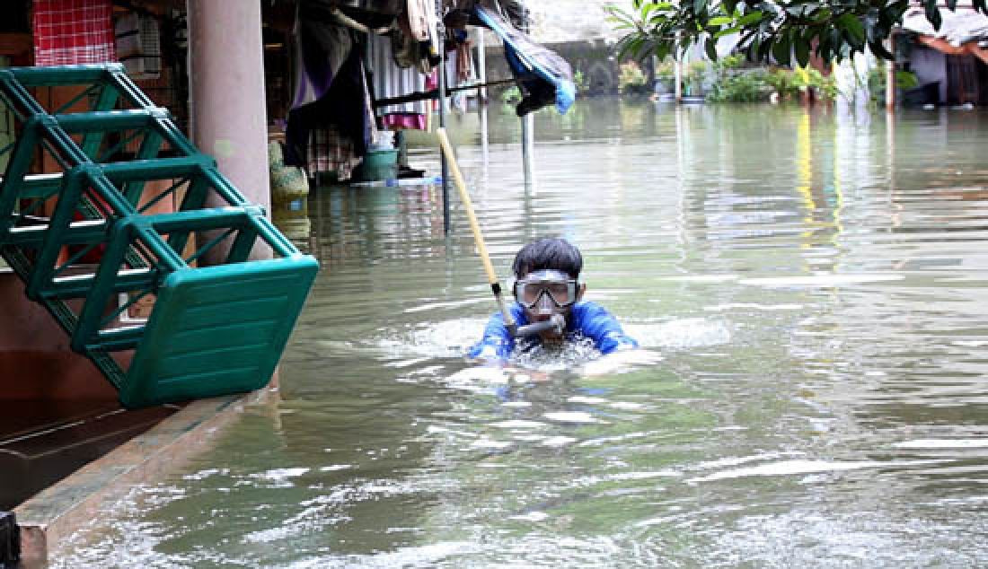Anak anak bermain di depan rumah yang terendam banjir di kawasan Kemang Utara, Jakarta Selatan, Selasa (21/2). Hujan yang mengguyur Ibu Kota sejak pagi tadi mengakibatkan banjir di sebagian wilayah Jakarta. - JPNN.com