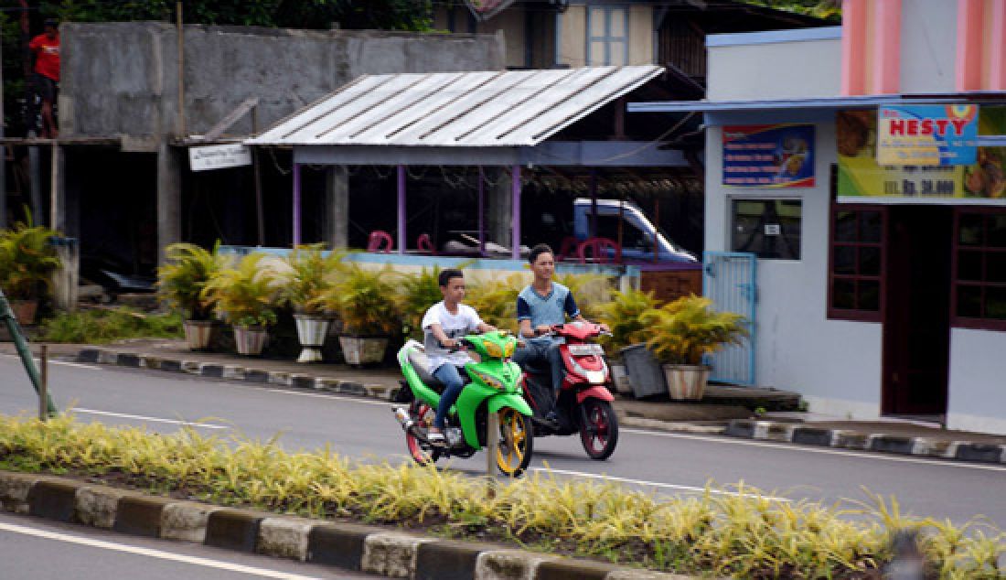 JANGAN DITIRU: Para siswa berkendara motor di ruas Jalan AA Maramis tidak menggunakan helm, Rabu (22/2). Aksi tersebut jelas membahayakan nyawa mereka. - JPNN.com