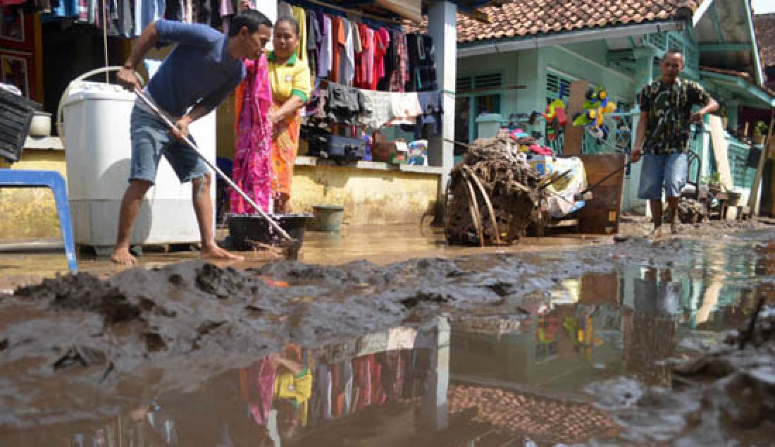 Sejumlah warga saat membersihkan tumpukan lumpur tebal yang membekas di sekitaran rumah dan lingkungan paska diterjang banjir di kelurahan pesawahan, Teluk Betung Selatan, Bandarlampung, Rabu (22/2). - JPNN.com