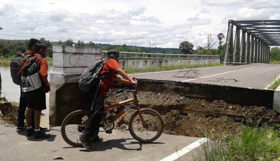 Jalan di pangkal jembatan di Desa Karang Raja, Kecamatan Muara Enim amblas dan mengakibatkan jembatan Enim III putus, Kamis (23/2). Beruntung tidak ada korban jiwa atas peristiwa ini dan jembatan Enim III tidak ambruk ke masuk sungai Enim. - JPNN.com