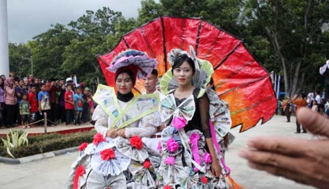 Dua wanita dengan kostum unik dari bahan koran turut meramaikan Pawai Budaya dalam rangka memperingati Hari Jadi Kabupaten Konawe, Sulawesi Tenggara ke-57. - JPNN.com