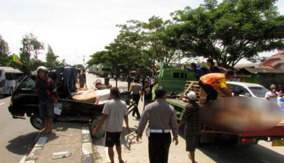 EVAKUASI: Polisi dibantu warga sekitar mengevakuasi korban tabrakan antara pick up pembawa jenazah dengan colt diesel di Desa Patrol, Indramayu Selasa, (28/2). Dalam kejadian tersebut lima orang tewas. - JPNN.com